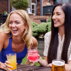 A mixed group of people enjoying cocktails in a beer garden.