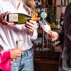 3 people in a bar enjoying a glass of champagne