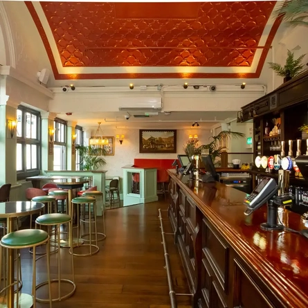 Interior or bar on the right and tables lined down the left with bar stools