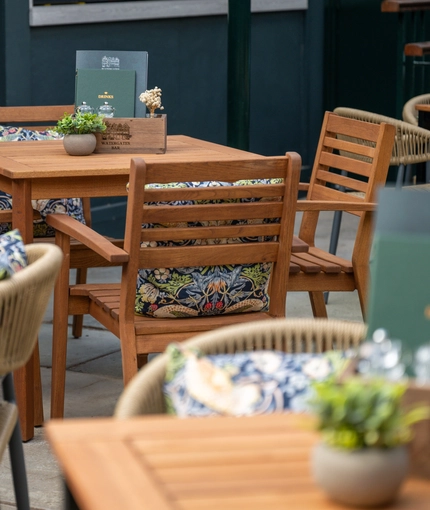 The exterior patio beer garden seating area with tables, chairs and scatter cushions at The Watergates Bar.