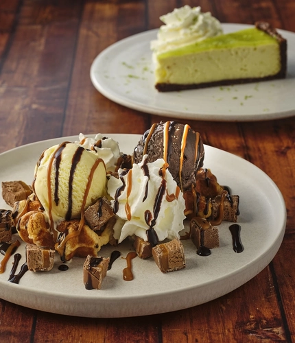 A waffle with ice cream and Mars bar, and a slice of mojito key lime pie served on plates at Flaming Grill.