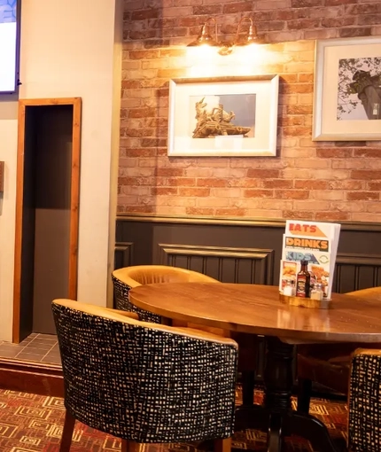 The interior restaurant and seating area with TV and fireplace at the Kingstown Hotel.