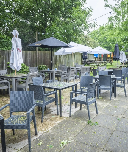 Exterior beer garden and playground of a pub with a seating area.