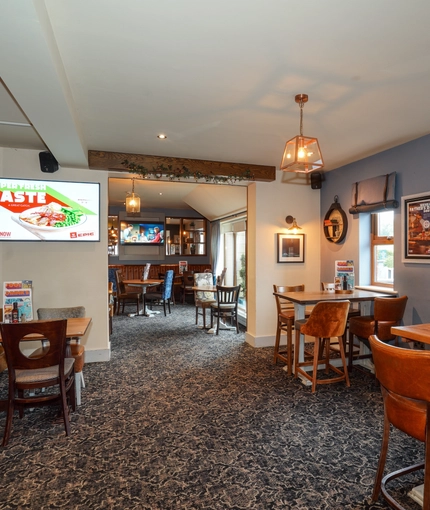 Interior dining area of a pub with a TV.