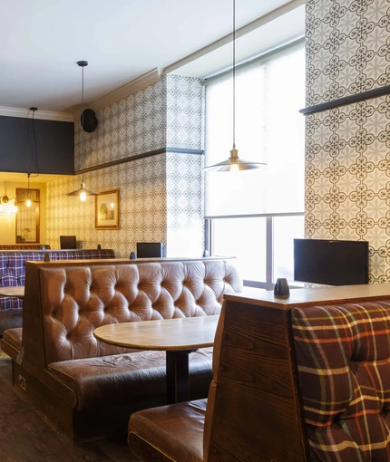 Interior dining area of a pub with TVs.