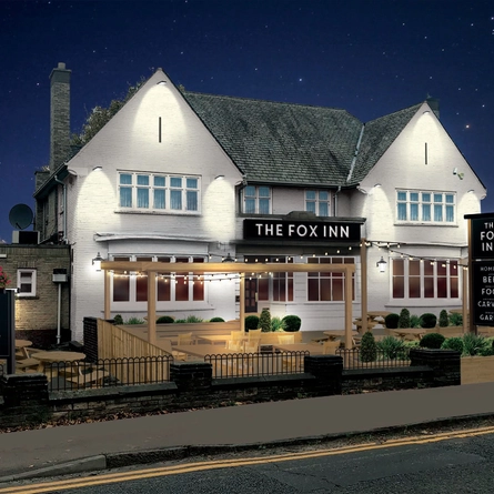 The exterior facade with outdoor seating area and venue signage at The Fox Inn.
