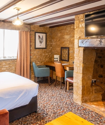 A suite bedroom with a sofa and coffee table at The Red Lion, Adderbury.