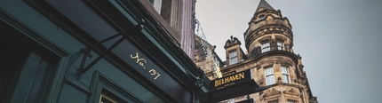 A close up view of the pub sign hanging on an exterior wall of the Albanach in Edinburgh.