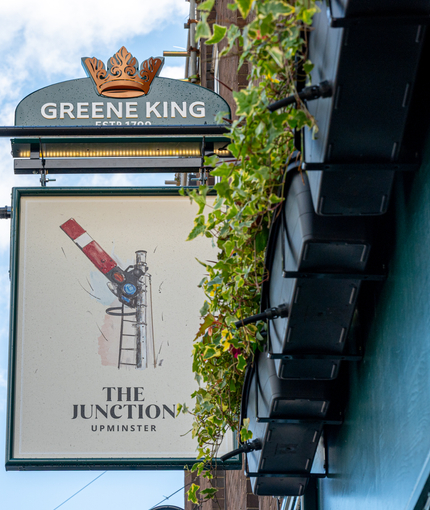 A close up view of the pub sign hanging on the exterior wall of The Junction.