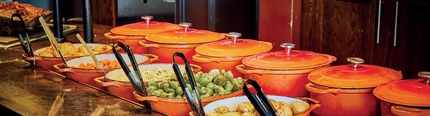 Carvery counter with food in dishes under a hot plate