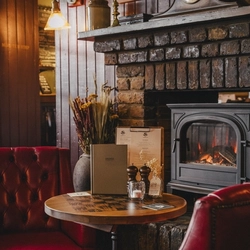 The interior restaurant and seating area with fireplace at the Three Tuns.