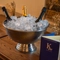 An image of an ice bucket bowl containing various bottle of sparkling white wine sat on a table within the interior of The Kings Stores.
