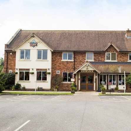 Exterior facade of a pub with a car park.