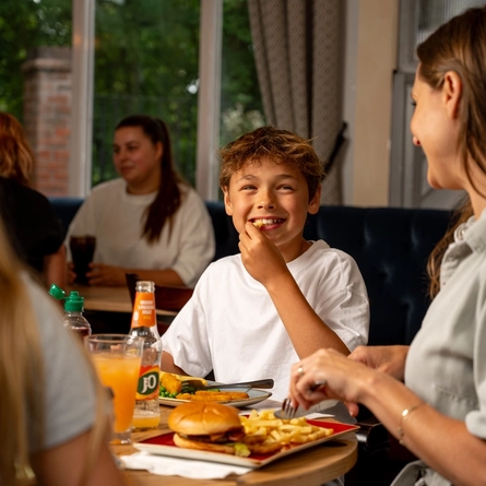 A family sat at an indoor table enjoying a meal and drinks at a Hungry Horse venue.