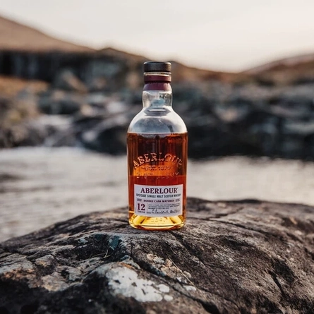 A bottle of Aberlour whiskey with a rocky background.