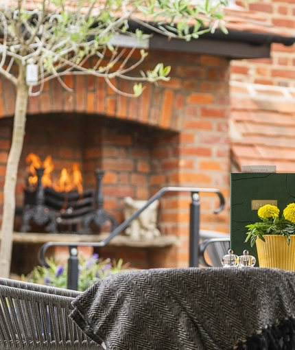 The exterior beer garden seating area with outdoor open fire and fireplace at The Crown.