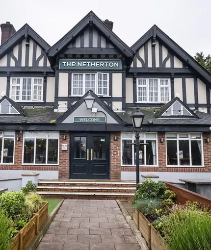 Exterior facade of a pub with a seating area.