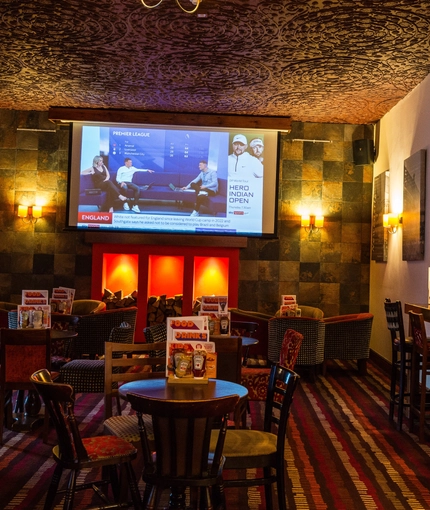 Interior dining area of a pub with a fireplace and a TV.