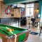 An interior restaurant seating area at Whitehills in Northampton, with TVs on the walls, a dartboard, and a pool table.