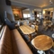 Interior dining area of a pub with a TV, a bar and a gambling machine.