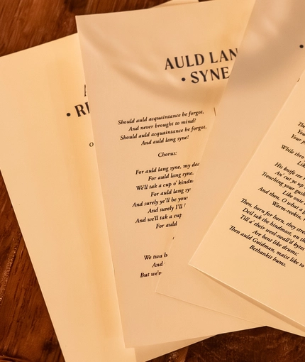 An image of a collection of printed poems and songs sat on a table within the interior function room during a Burns Night Event at The Crabtree.