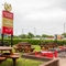 The exterior beer garden and seating area with pub signage at the Poachers.