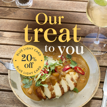 A banner showing a curry dish and cocktail style drink sat on a wooden table within the exterior beer garden seating area to promote a 20% Off Offer for Blue Light Card Holders at Chef & Brewer.