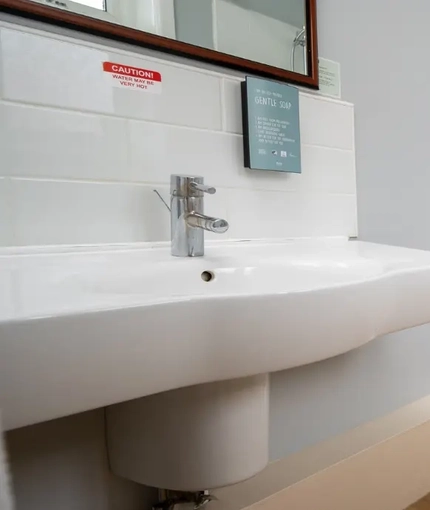 The interior hotel bathroom with bath, toilet and sink at The Commodore.