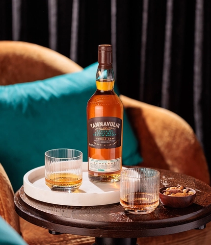 A tray on an indoor coffee table, with a bottle of Tamnavulin and a couple of glasses containing liquid.