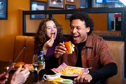 A family enjoying a meal and drinks in the interior restaurant from the new Spring/Summer menu at Flaming Grill.