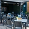 The exterior beer garden seating area of the Cock & Pye, with flowers and menus on each table and a TV on the wall.
