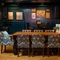 The wood panelled interior restaurant seating area of the Cock & Pye, with a large wooden dining table and upholstered seats.