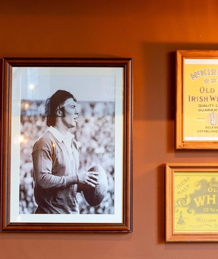 Framed artwork and photographs on a wall inside Molly Malones in Aberdeen.