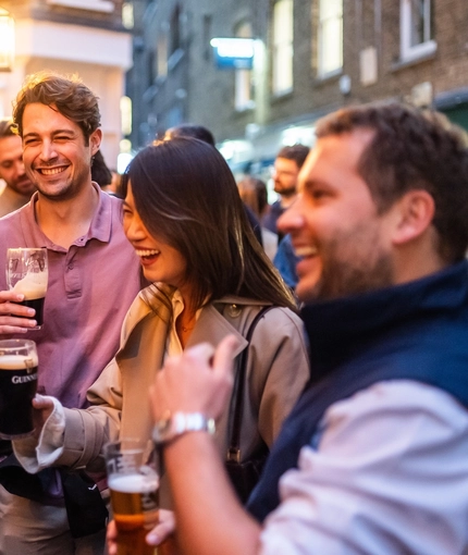 An image of a group of friends enjoying a selection of drinks stood outside The Kings Stores.