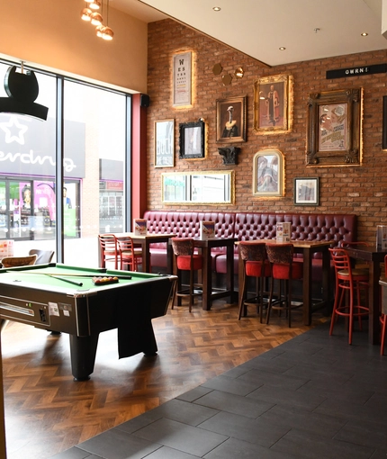 Interior bar and dining area of a pub with a pool table.