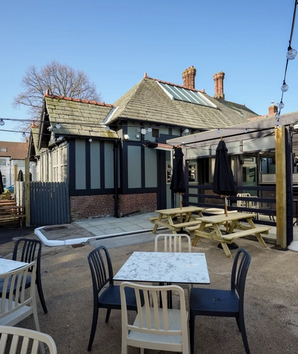 Exterior beer garden with wooden picnic benches