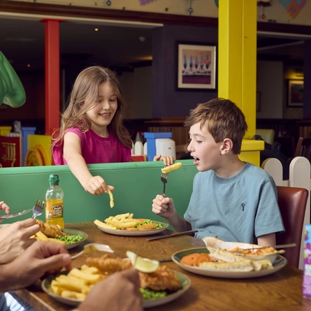 Kids enjoying children's food for the 'Kids-Eat-Free' promotion at Farmhouse Inn venues.