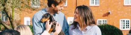 A lifestyle image of customers enjoying drinks within the beer garden with their dog at a Greene King Pub.