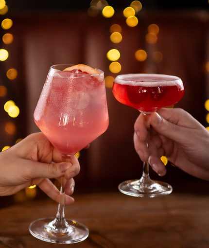 a man and a woman cheering with cocktails