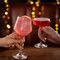 a man and a woman cheering with cocktails