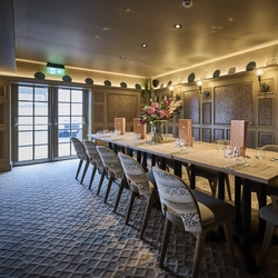 Large dining table set up with cutlery in a function room