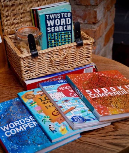 A table set up with puzzle books and a games hamper