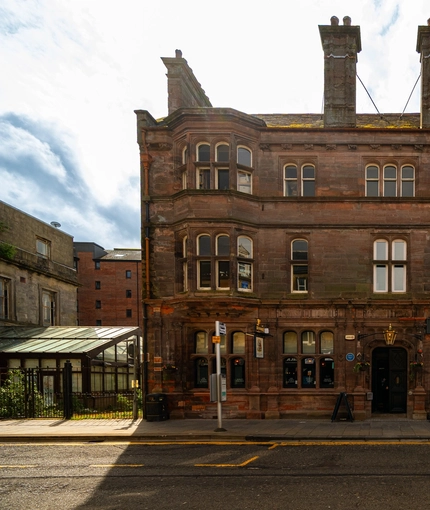 The exterior facade and signage of the Counting House in Dumbarton, with a large glass lantern hanging above the door.