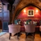 An image focusing on one of the interior restaurant seating area tables situated within a gothic stone arch with chairs, cushioned seating and wooden flooring at The Watergates Bar.
