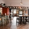 Interior dining area of a pub with a dartboard and a gambling machine.