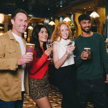 A lifestyle image of 4 friends stood enjoying various drinks within the interior of an Urban Core Venue.