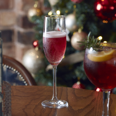 An advertising image of 2 cocktail style drinks sat on a table within the interior restaurant seating area at a Chef & Brewer venue.
