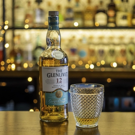 A bottle and poured glass of Glenlivet Whiskey.