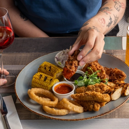 Two people enjoying a Chicken Sharer.