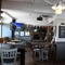 Interior dining area of a pub with a bar, a TV and a fireplace.